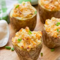 These gluten-free greek yogurt twice baked potatoes are perfectly portioned baked potatoes that are then loaded with healthy creamy greek yogurt, bacon crumbles, spices, and cheese and then baked a second time until the tops are golden brown and crunchy.