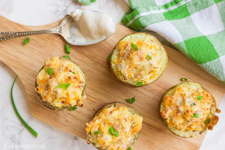 These gluten-free greek yogurt twice baked potatoes are perfectly portioned baked potatoes that are then loaded with healthy creamy greek yogurt, bacon crumbles, spices, and cheese and then baked a second time until the tops are golden brown and crunchy.