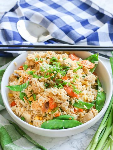 fried rice with chicken and peas in white bowl