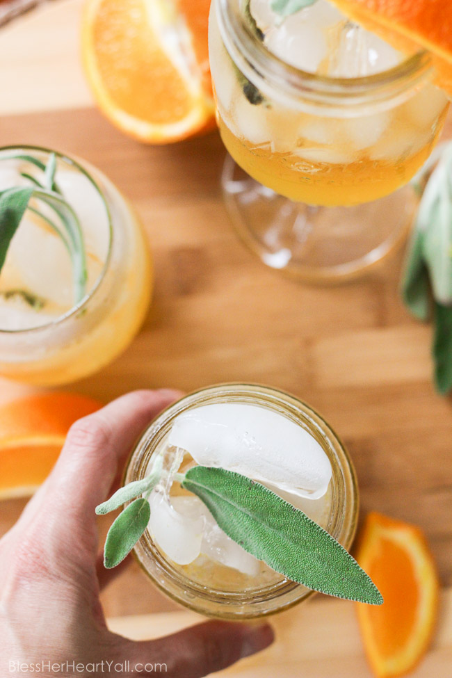 This honey bear cocktail is the perfect cocktail to sip on during those chilly fall evenings with friends on your porch or for entertaining those guests as they walk in the front door of your Thanksgiving day festivities. Made with a simple syrup of honey, sage, and orange, then combined with southern bourbon over ice, you will be sipping on a fresh, mellow, slightly sweet cocktail that everyone {including those honey bears!} will find perfect all fall long. www.blessherheartyall.com