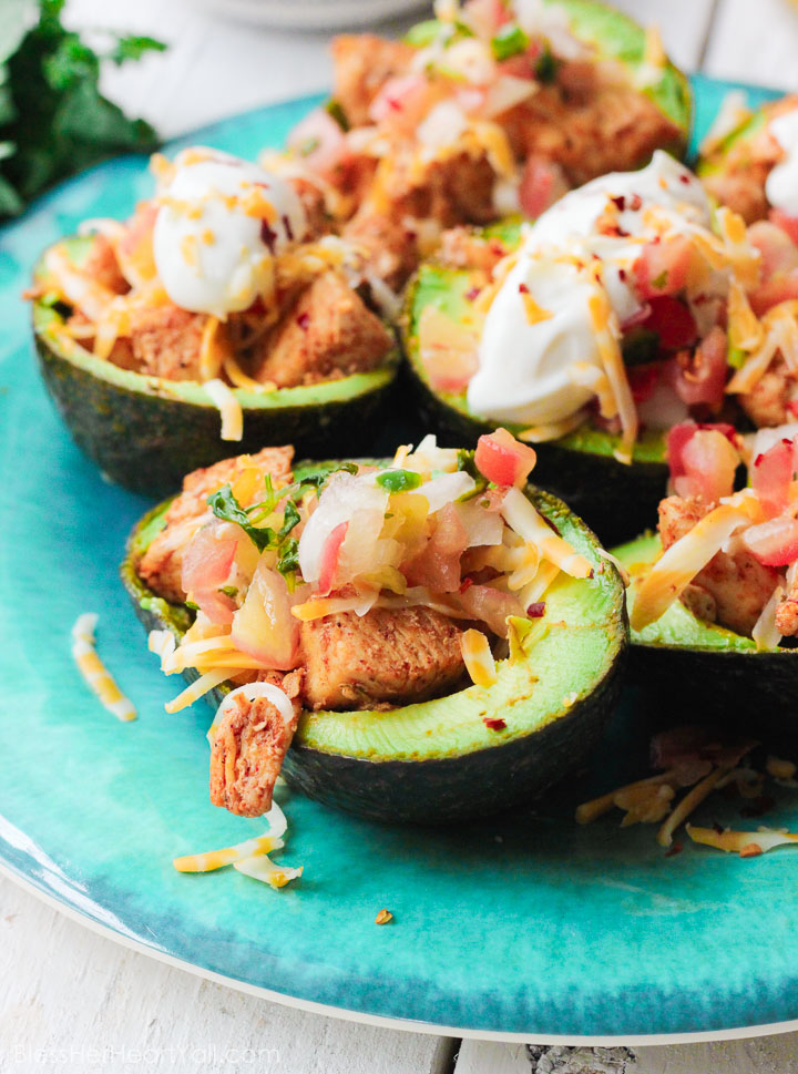 These chicken taco avocado boats are a quick and tasty option for your party or appetizer table. These are a healthy alternative to tacos while keeping that punch of flavor! www.BlessHerHeartYall.com