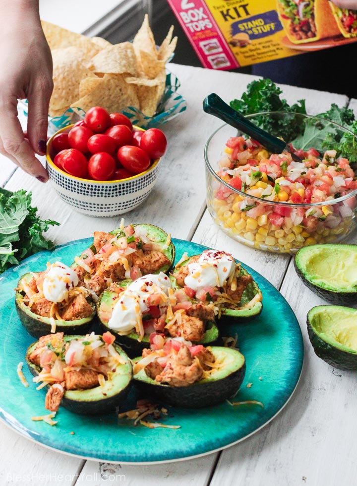 These chicken taco avocado boats are a quick and tasty option for your party or appetizer table. These are a healthy alternative to tacos while keeping that punch of flavor! www.BlessHerHeartYall.com