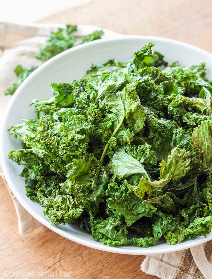 These easy Garlic Kale Chips are just as tasty as store bought chips, are just as inexpensive, and can be made in just minutes! www.BlessHerHeartYall.com