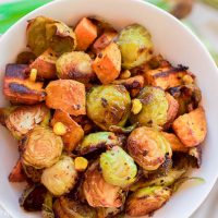 This healthy roasted sweet potato brussel sprout hash is a simple fall treat that drizzles on a light layer of olive oil, garlic, and cumin before roasting. The vegan and gluten-free recipe produces perfectly golden baked sweet potato pieces surrounded by fresh spiced corn kernels and crisp and tender cooked brussel sprouts.