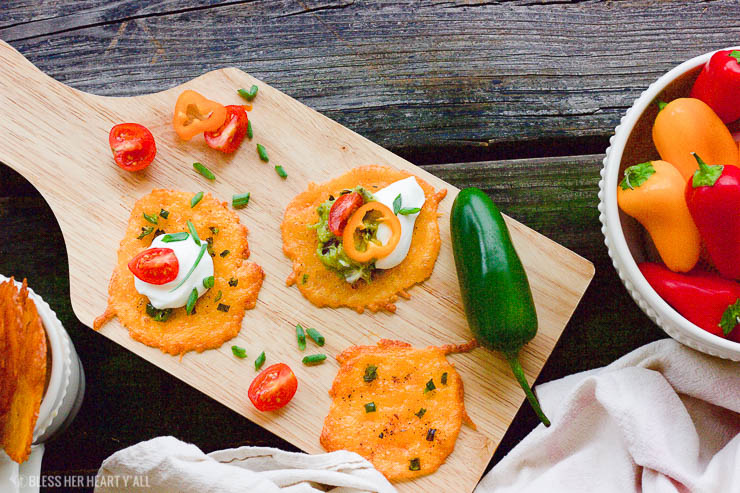 Taco cheese crisps are an easy and quick baked party recipe! These crispy cheese dippers are the perfect appetizer or snack for any gluten-free or low carb munchers and are huge hits at tailgating parties! All you need is cheddar cheese, taco seasoning, your favorite taco toppings, and a few minutes of oven time! Yes!