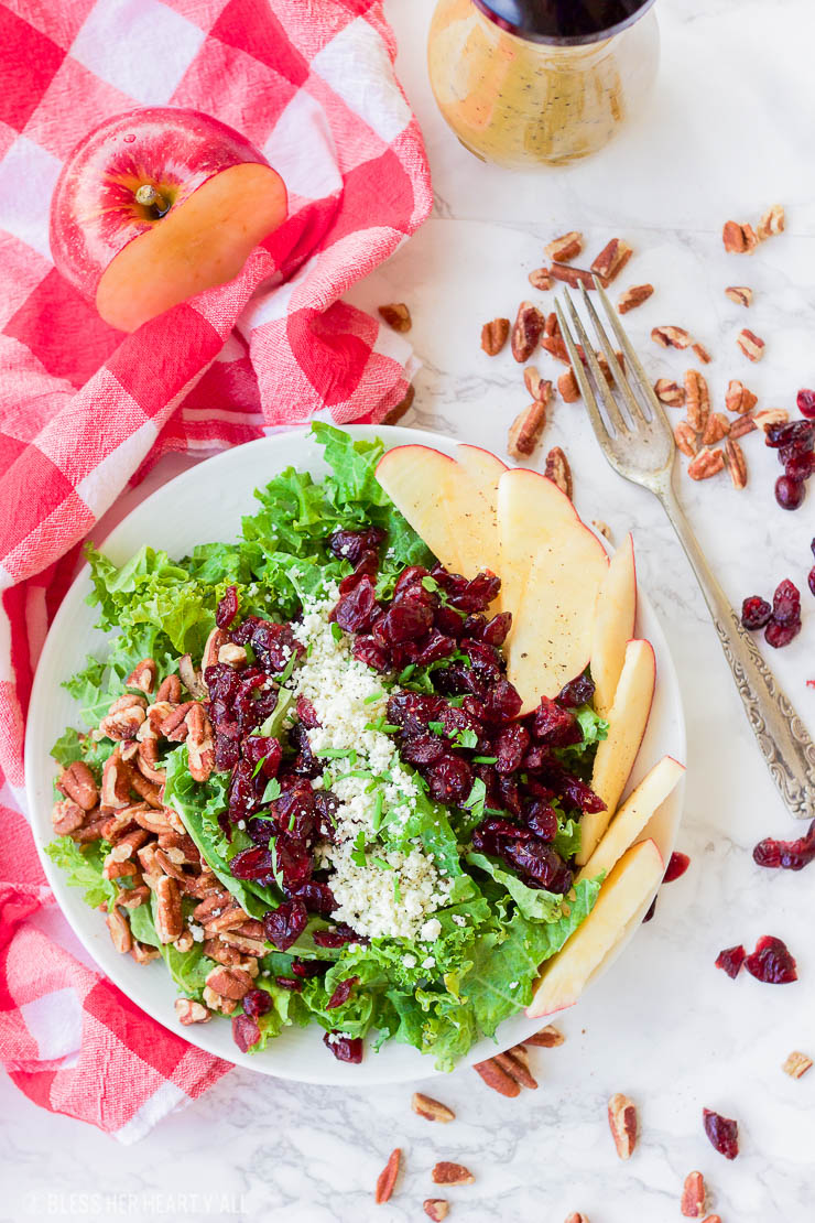 This apple cider poppyseed salad throws the season's best combination of juicy apples, crunchy pecans, sweet cranberries, and savory blue cheese crumbles over a bed of chopped kale and drizzles on a 2-minute apple cider poppyseed vinaigrette. It's big on nutrients and fall flavors and is gluten-free and paleo-friendly! www.blessherheartyall.com