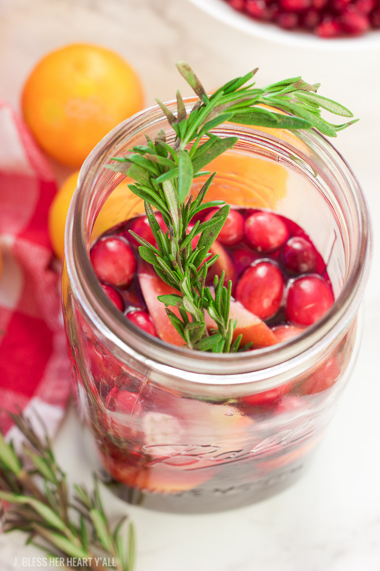 This winter pomegranate cranberry sangria recipe is a quick and easy twist on the popular sangria drink. Impress everyone at your next holiday or Christmas party with this sparkling red wine cocktail with apples, oranges, pomegranate, cranberry, rosemary, and cinnamon sticks! Get your drink on fancy pants!