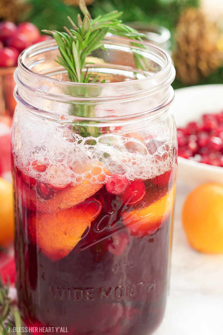 This winter pomegranate cranberry sangria recipe is a quick and easy twist on the popular sangria drink. Impress everyone at your next holiday or Christmas party with this sparkling red wine cocktail with apples, oranges, pomegranate, cranberry, rosemary, and cinnamon sticks! Get your drink on fancy pants!