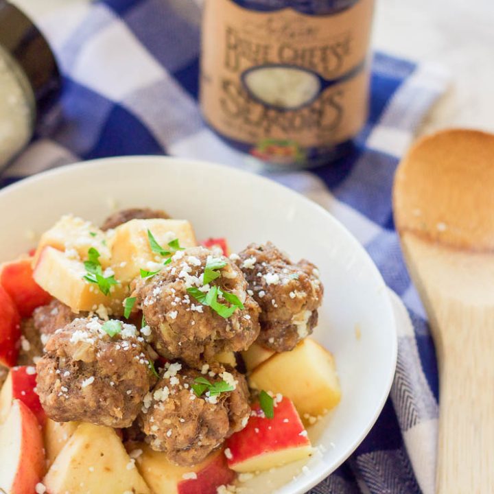 This easy slow cooker apple cider meatballs recipe dunks fresh meatballs and juicy apple slices in apple cider, garlic, and blue cheese crumbles for a delicious fall spin. Bring them to a fall party and they will be gone in seconds! www.BlessHerHeartYall.com