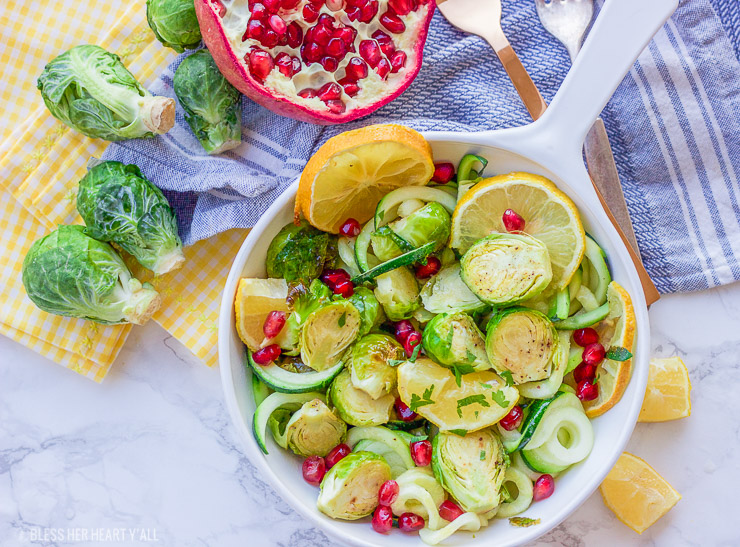 This lemon garlic roasted brussel sprouts + zucchini recipe is a clean, crisp, savory vegetable dish that is not only healthy but a gorgeous and easy addition to any meal! Lemon, honey, and garlic flavors coat the roasted brussel sprouts, zucchini noodles, and pomegranate arils for a colorful fresh salad.