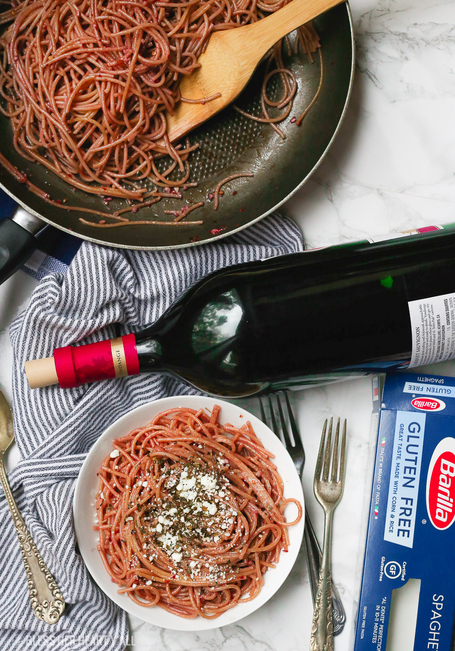 This gluten free red wine pasta + garlic basil goat cheese sauce is the perfect quick and fancy date night recipe that's ready in under 20 minutes! The gluten free pasta is cooked and stained in red wine and then tossed in a creamy garlic basil goat cheese sauce.