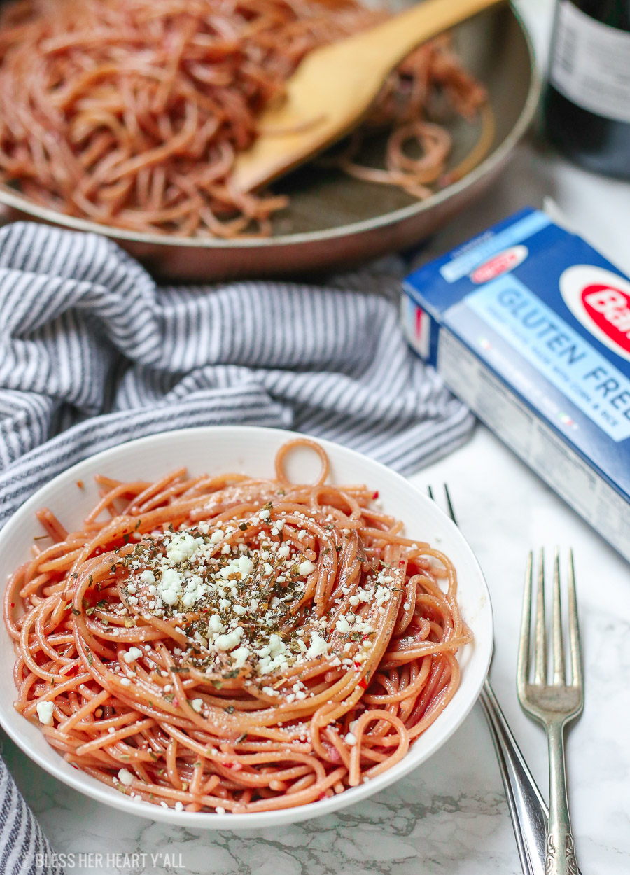 This gluten free red wine pasta + garlic basil goat cheese sauce is the perfect quick and fancy date night recipe that's ready in under 20 minutes! The gluten free pasta is cooked and stained in red wine and then tossed in a creamy garlic basil goat cheese sauce.