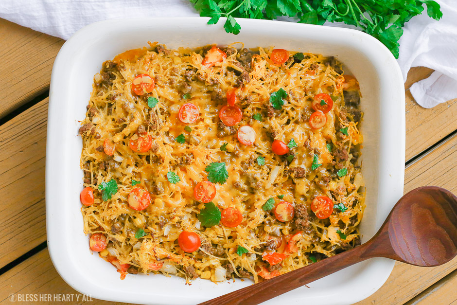 Spaghetti squash taco bake roasts fluffy spaghetti squash and melts it into seasoned ground meat, tomatoes, onion, corn, beans, and tops it off with melty cheese and fresh cilantro for the perfect healthy taco-inspired casserole!