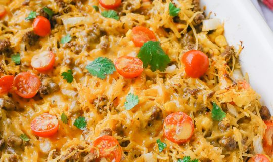 Spaghetti squash taco bake roasts fluffy spaghetti squash and melts it into seasoned ground meat, tomatoes, onion, corn, beans, and tops it off with melty cheese and fresh cilantro for the perfect healthy taco-inspired casserole!