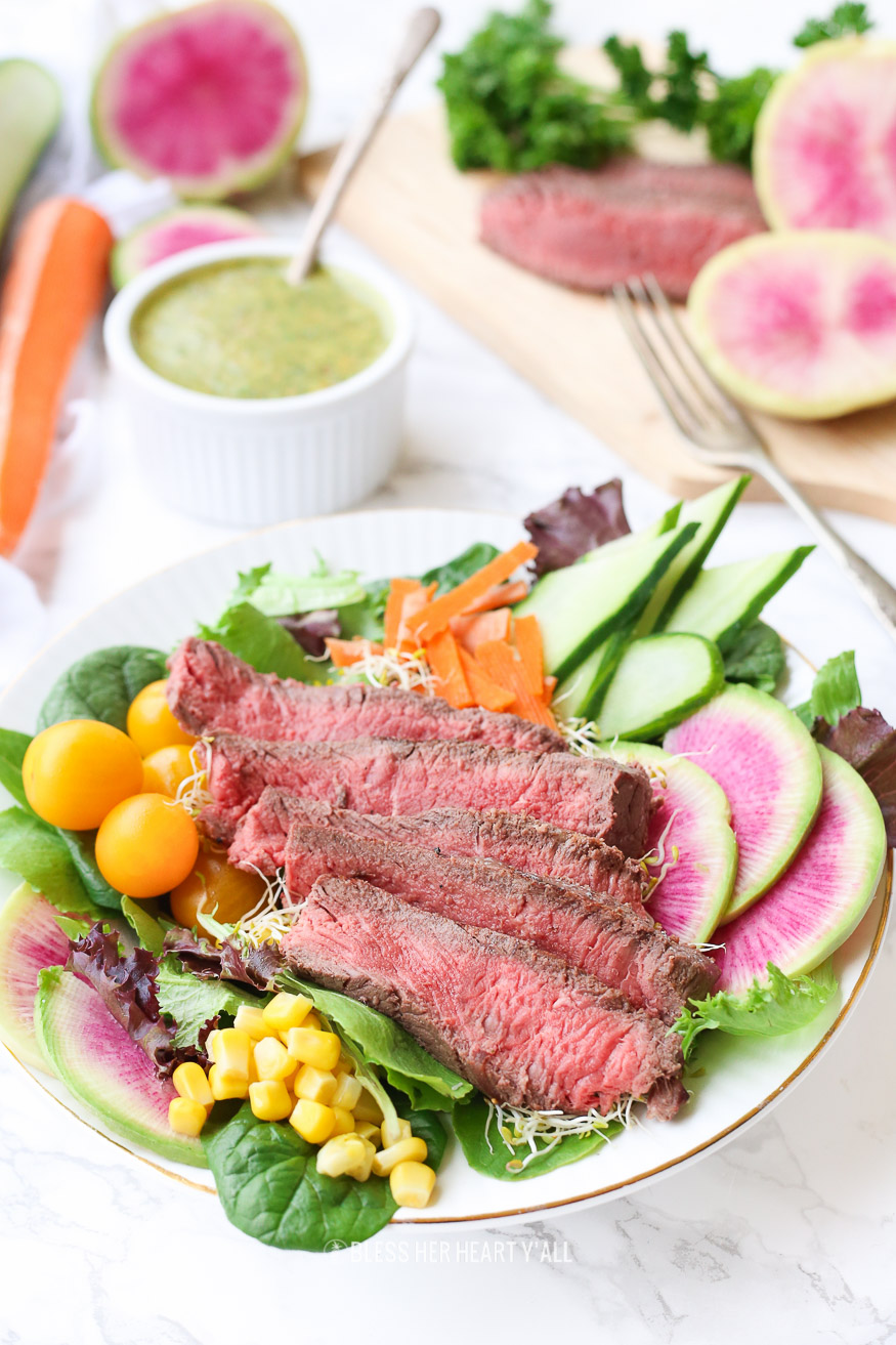 This spring steak salad with homemade carrot and cilantro chimichurri vinaigrette dressing uses crisp spring vegetables and tops them with tender juicy steak pieces and a drizzle of fresh herb chimichurri sauce. Colorful vibrant vegetables combined with high-quality steak choices from our sponsor PRE Brands make this salad a standout showstopper. 