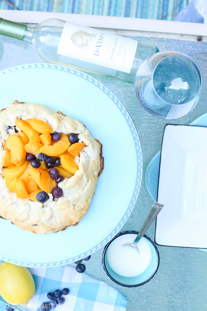 This peach blueberry galette combines peach slices and fresh blueberries in a sweet juicy sauce and then spreads it inside a doughy sugar-lined crust and bakes it all to golden perfection. This gluten free tart is drizzled in a light lemon glaze and is the perfect summer snack to enjoy outside on the back deck with a chilled bottle of white wine!