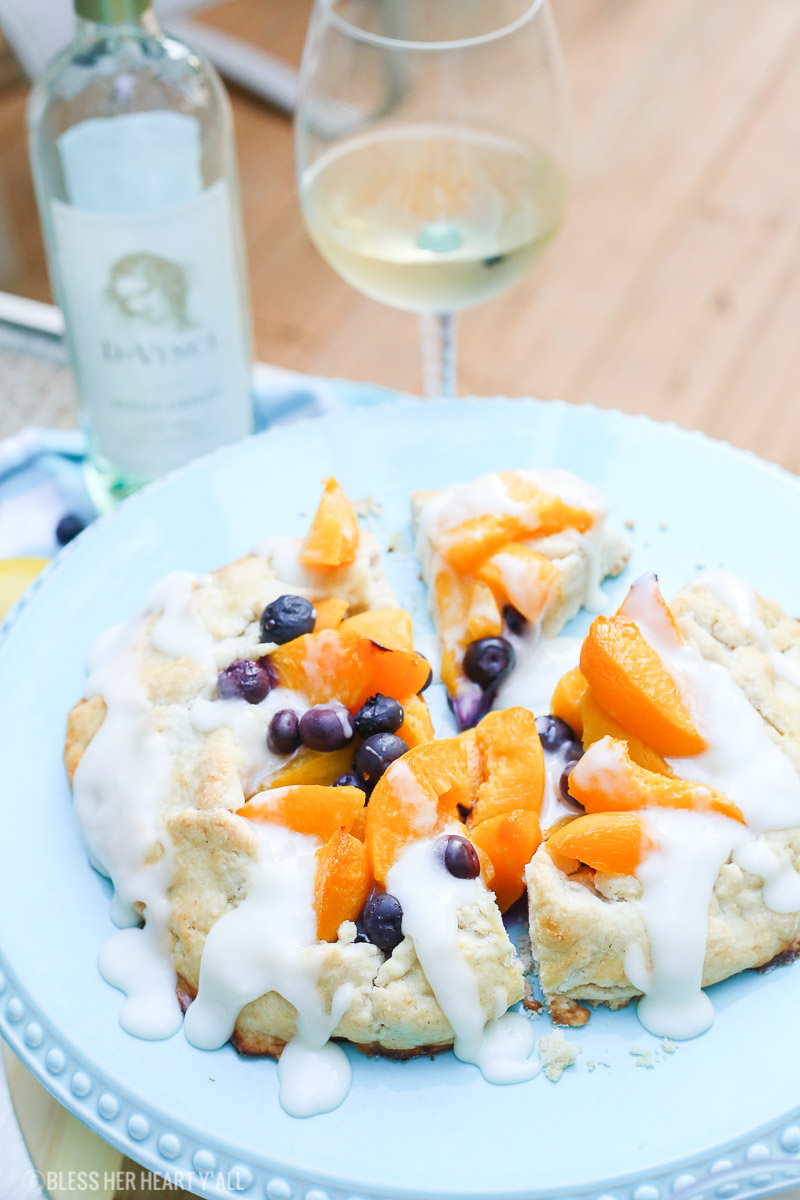 This peach blueberry galette combines peach slices and fresh blueberries in a sweet juicy sauce and then spreads it inside a doughy sugar-lined crust and bakes it all to golden perfection. This gluten free tart is drizzled in a light lemon glaze and is the perfect summer snack to enjoy outside on the back deck with a chilled bottle of white wine!