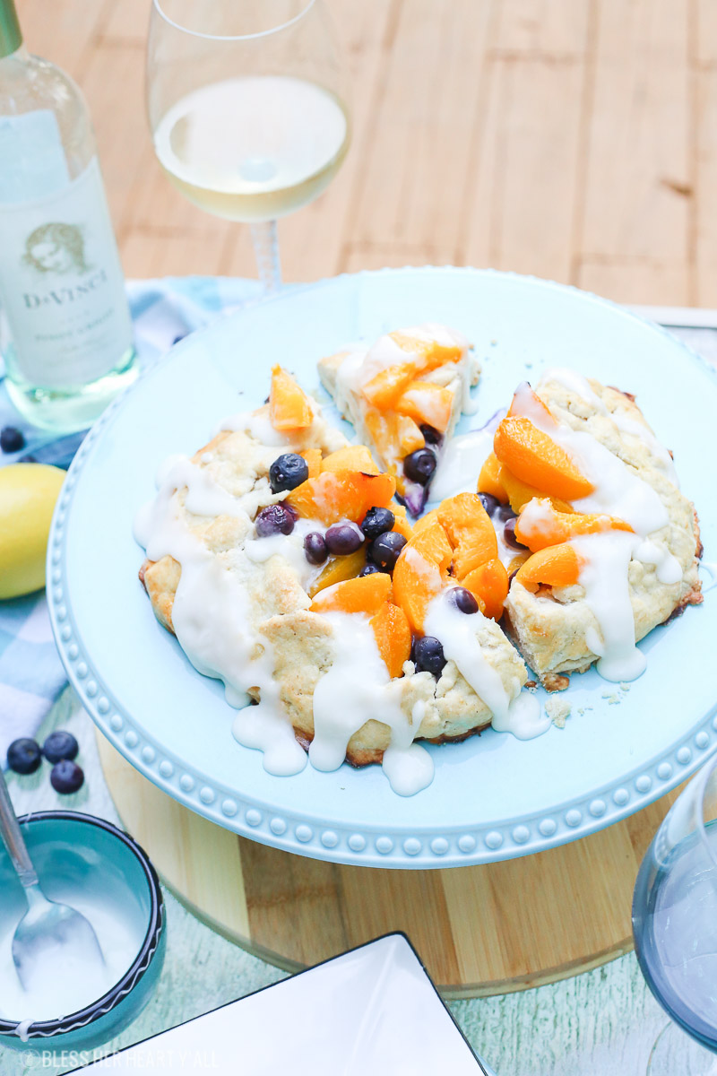 This peach blueberry galette combines peach slices and fresh blueberries in a sweet juicy sauce and then spreads it inside a doughy sugar-lined crust and bakes it all to golden perfection. This gluten free tart is drizzled in a light lemon glaze and is the perfect summer snack to enjoy outside on the back deck with a chilled bottle of white wine!