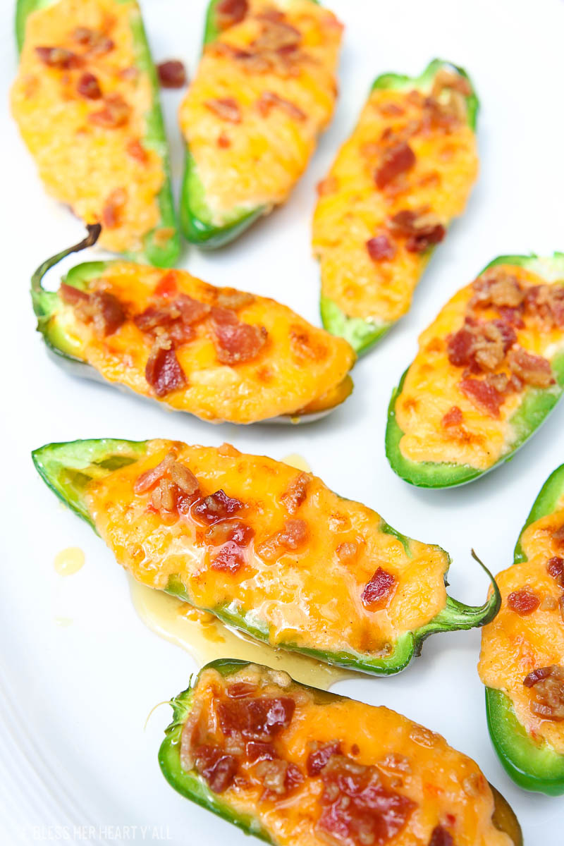Pimento cheese jalapeno poppers melt fresh jalapenos and pimento cheese together and then top them with crisp bacon crumbles and a drizzle of fresh honey. Each bite combines sweet and spicy with warm melty cheese and crunch. The perfect snack or appetizer in just 5 minutes!