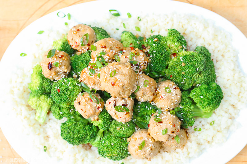 Sesame ginger paleo turkey meatballs bake soft paleo meatballs in a drizzle of homemade sweet and zesty sesame ginger sauce and topped with sesame seeds and green onion slivers. It's the perfect gluten-free, grain-free, and dairy-free appetizer or meal over rice and steamed vegetables! image 4