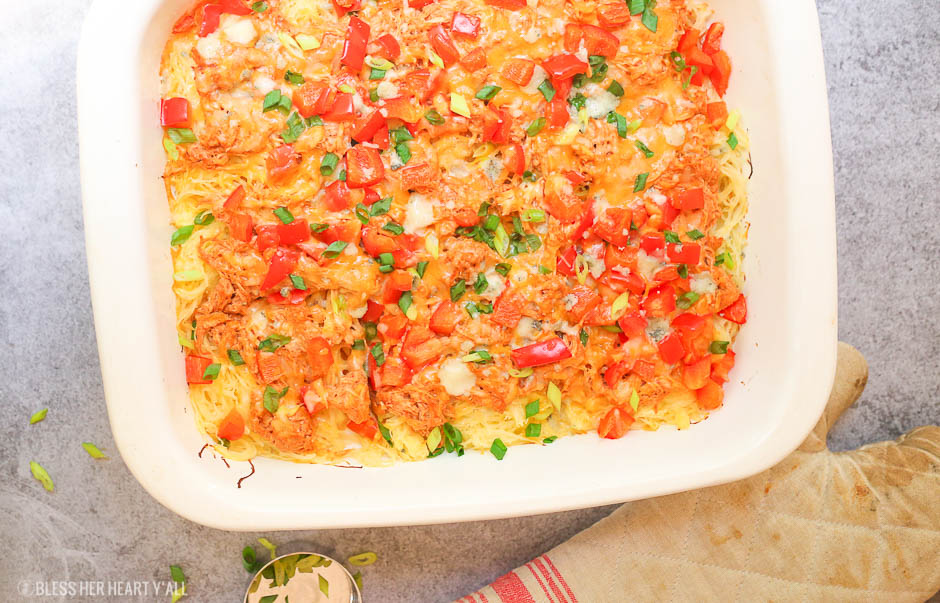 Skinny buffalo chicken spaghetti squash bake combines creamy flavor-packed buffalo chicken with fresh veggies and blue cheese crumbles all on a bed of spaghetti squash!