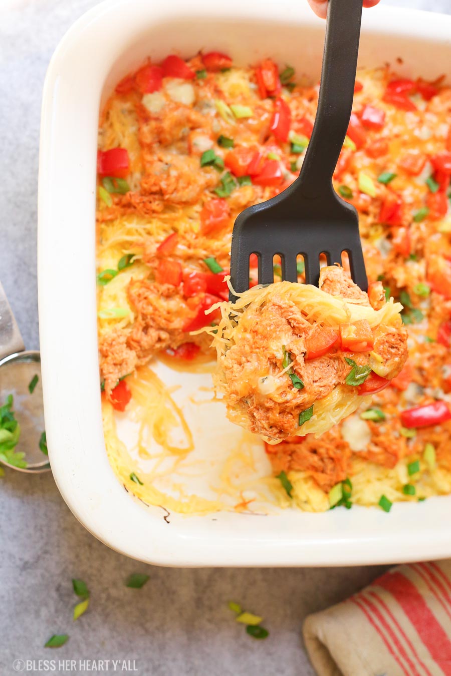 Skinny buffalo chicken spaghetti squash bake combines creamy flavor-packed buffalo chicken with fresh veggies and blue cheese crumbles all on a bed of spaghetti squash!