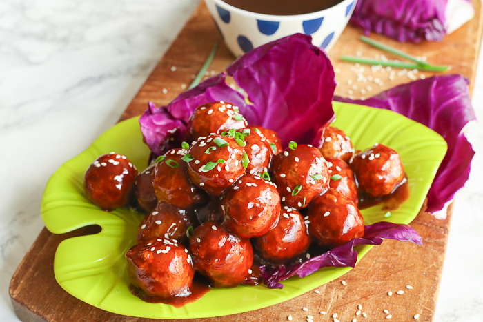 asian chicken meatballs stacked on bright green plate