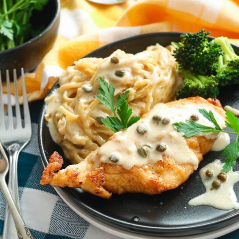 creamy instant pot chicken piccata that is gluten-free with pasta in black bowl with herbs