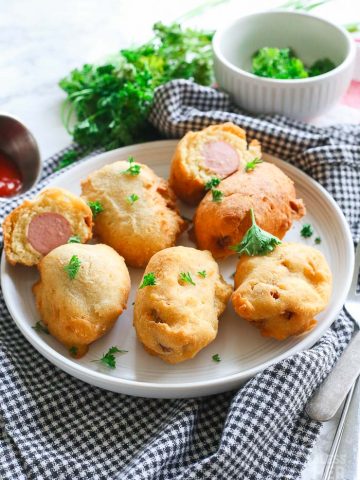 mini gluten free corn dogs on a white plate with ketchup