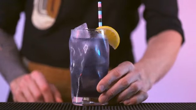 Tom Dyer showing the result of making a purple rain cocktail
